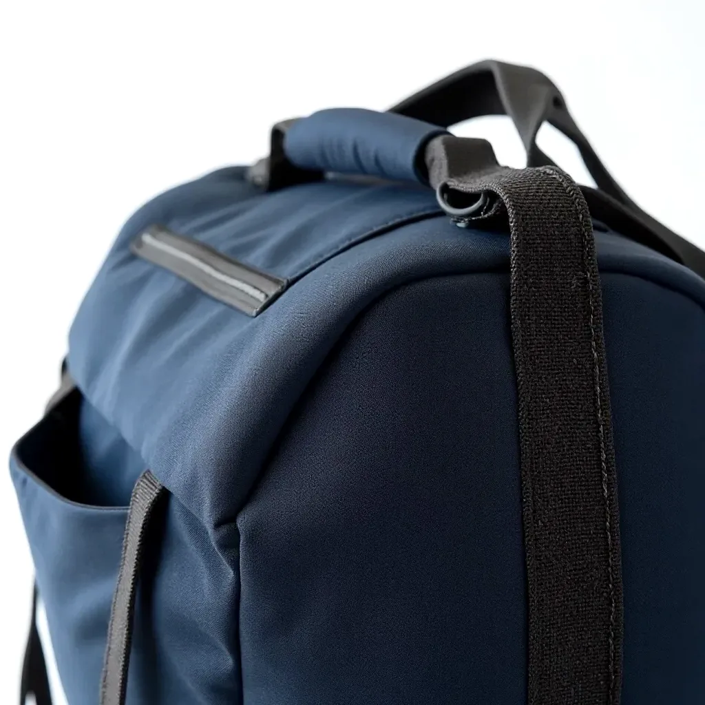 Detailed look at the duffel's construction, showing reinforced stitching, padded twin carry handles, and the textured polyurethane-coated polyester