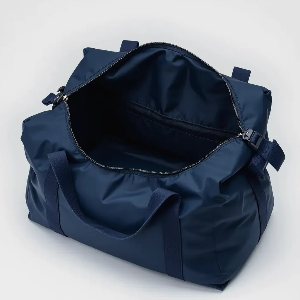Close-up of the navy duffel revealing its wet-dry divider, interior mesh pocket, and wide-mouth main compartment for easy access