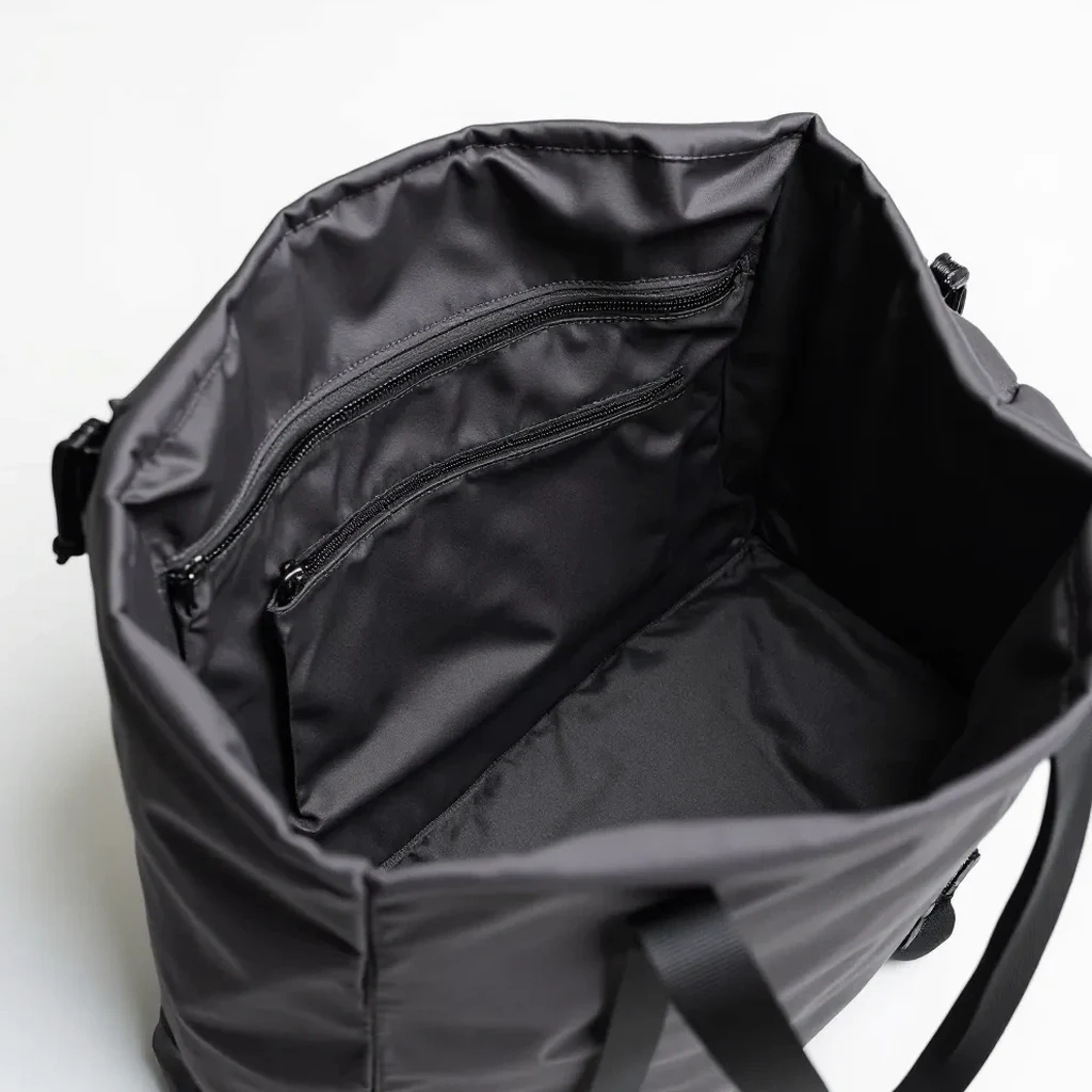 Inside view of the forest-green tote, showing the main compartment, a small zippered pocket, and the structured base panel